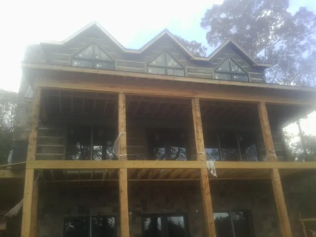Dormers and porch framing on a large log home under construction — Roof Coating work by our crew in Bethlehem