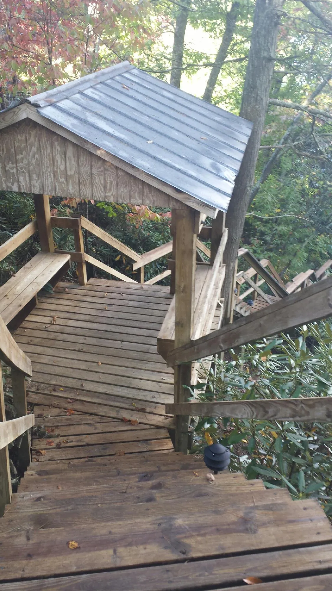 Metal roofed shelter over wooden steps on a wooded walkway — Skylight Repair & Installation work by our crew in Bethlehem
